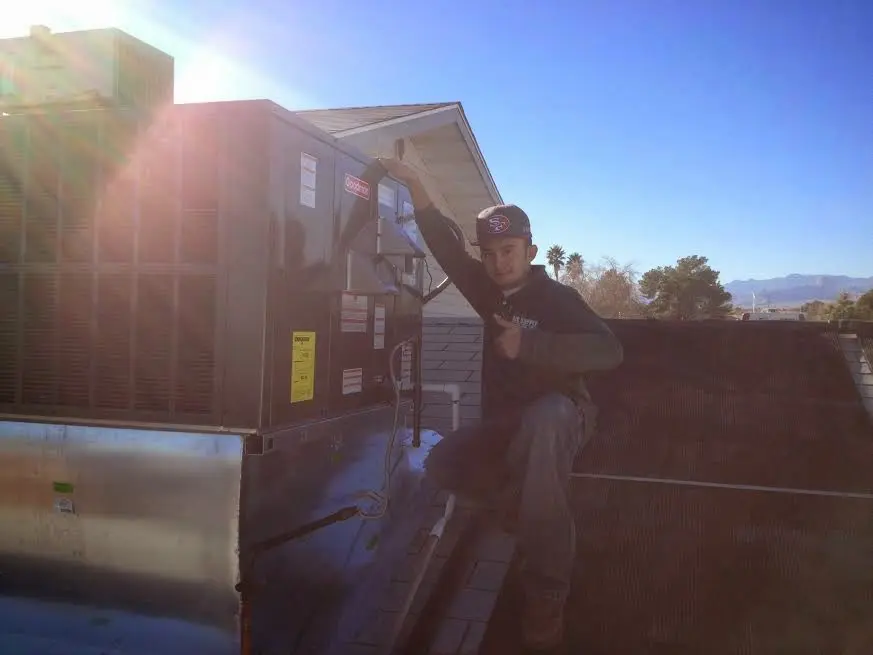 HVAC technician performing AC Tune-Up on a rooftop unit in Sullivan